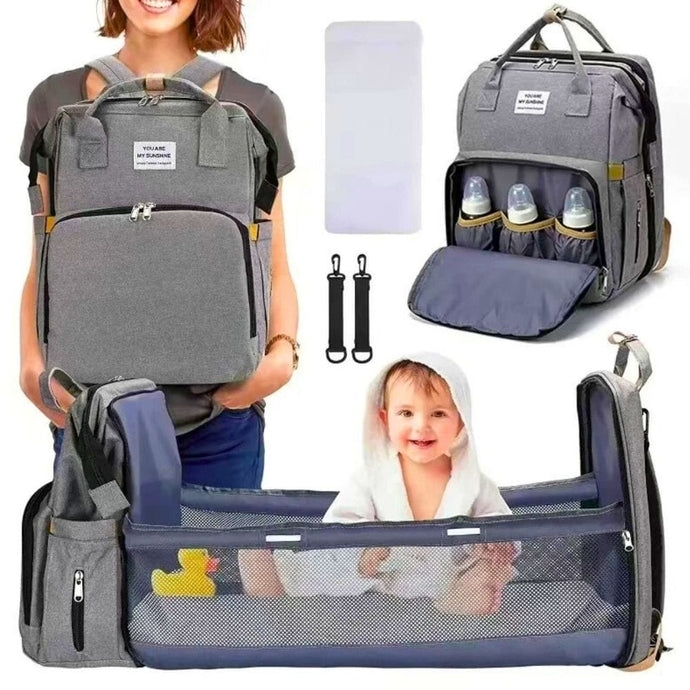 Sac à langer bébé avec lit intégré et plusieurs poches externes.